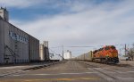 BNSF 7809 is pushing a westbound autorack train past the grain elevators in Hereford, TX